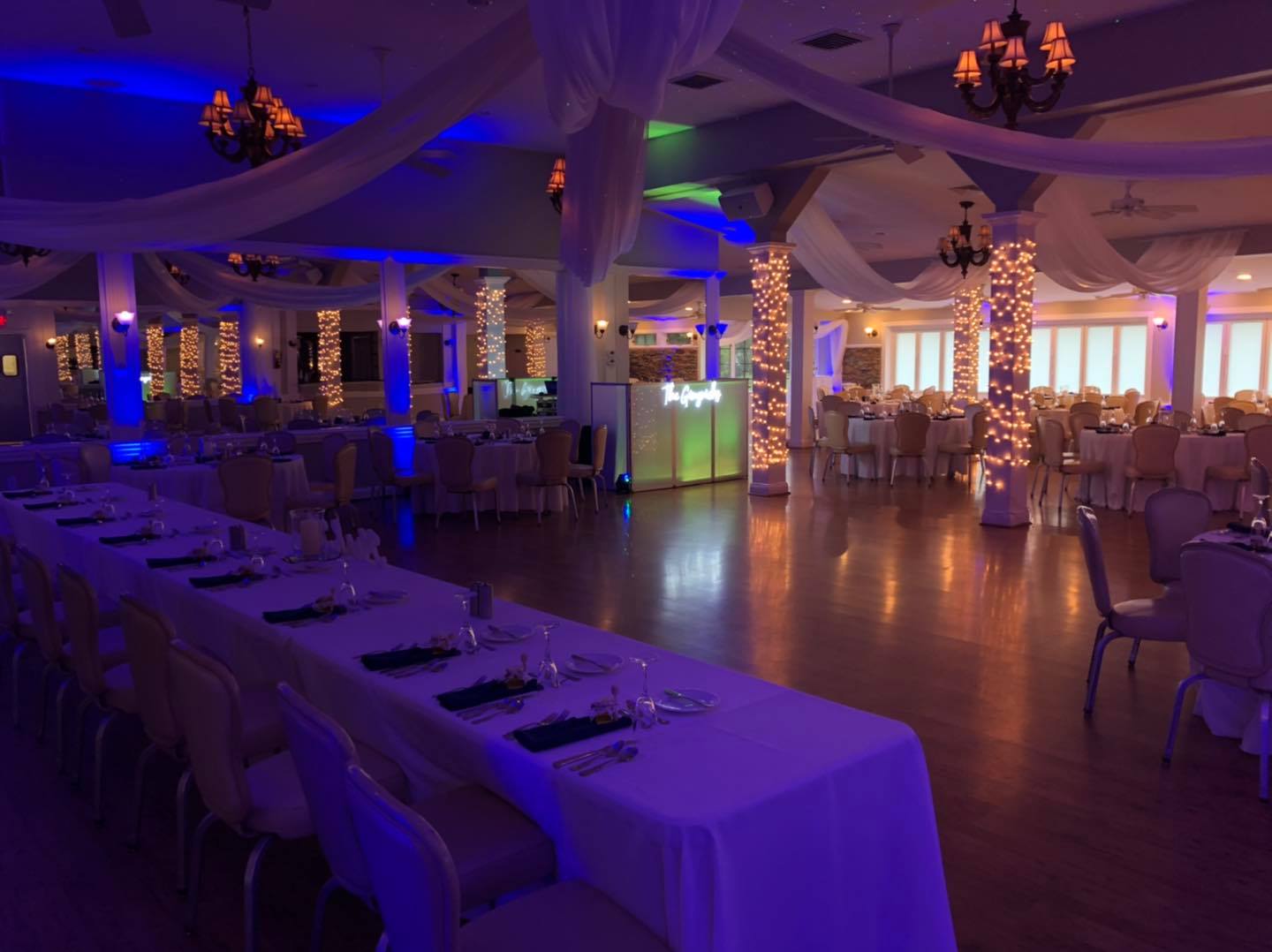 A Banquet Hall With Blue Lighting and White Drapes, Creating an Elegant and Serene Atmosphere.